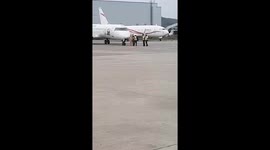 Airport ground staff duck to avoid being decapitated by plane's wing as pilot is suspended