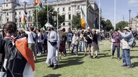 A pro-Palestinian protester is surrounded by multiple police officers outside the UK Parliament in London, before being escorted to a police vehicle.