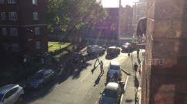 Crowds gather around car on fire