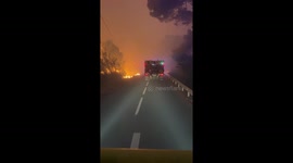 Firefighter vehicle passes through intense wildfire flames in Durban-Corbières