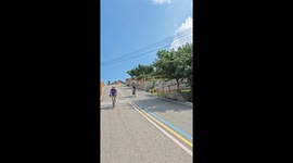 Cyclist ducks under lowered boom barrier in Hubei, China