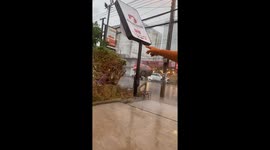 Thunderstorm leaves shop sign bent backwards in Thailand