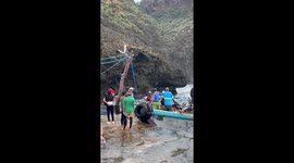 Tourists struggle to disembark from boat being rocked by sea