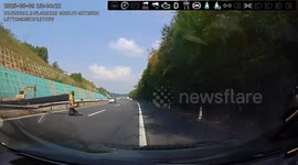 Crane topples onto busy highway sending passing car spiralling out of control