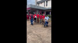 Worker shakes balls out of box tied to his back in amusing office party game