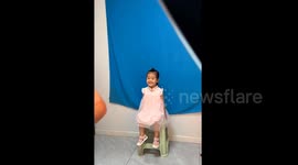 Little girl posing for ID photo seamlessly switches between serious and smiley expressions