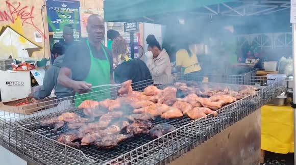 The chief prepares jerk chickens for the Carnival attendees at Powis Square., London UK