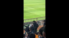 Football fan with head stuck in railings helped out by his friends