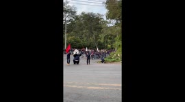 Students run uphill with panda mascot for university ceremony