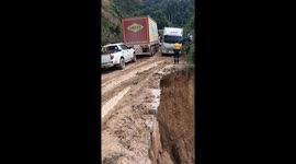 Trucks navigate narrow mountain road that collapsed in landslide