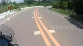 Motorcycle overtakes and nearly crashes into roadside barrier