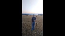 Man poses as friend walks backward on hay bale in Aberdeenshire, Scotland, UK