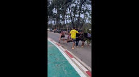 Tourist helps to move fallen tree from road on Thai island