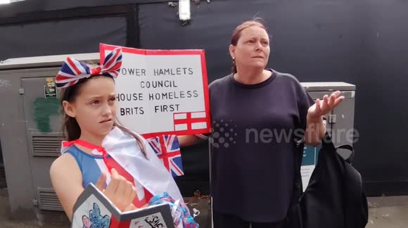 A mother and daughter are demonstrating against asylum seekers and illegal migrants outside the Britannia International Hotel in London, UK