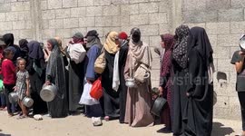 Hunger-stricken Palestinian line up for charity food aid in Gaza refugee camp