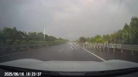 Driver skilfully regains control after skidding across wet road