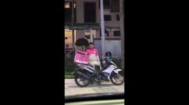 Delivery man persuades cat off his motorcycle in Kuala Lumpur, Malaysia