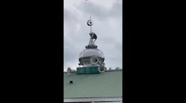 Monkey shakes dome on top of mosque