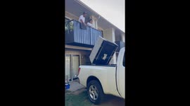 Man lifts couch over balcony in Nashville, Tennessee, USA