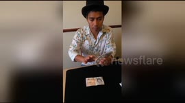 Magician makes bank note go through playing card