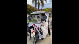 Bride drives trike with groom in the back to reach wedding reception