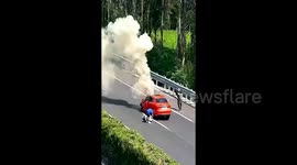 Car bursts into flames after crashing on highway, motorists join forces to rescue unconscious driver