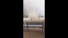 Children flee in panic as sudden dust devil tears across playing field
