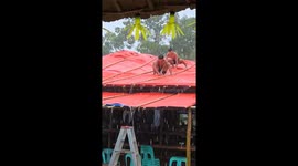 Residents cover church roof with tarpaulins as Typhoon Ragasa batters the Philippines