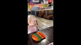 Little girl amazed by robot server in Panama City Beach, Florida, USA