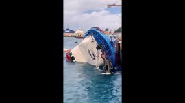 Ferry docked at port capsizes amid bad weather