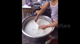 Man makes bread sticks with two chopsticks