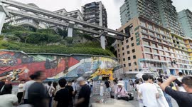 Tourists gather to watch trains entering a building at liziba station in chongqing, china