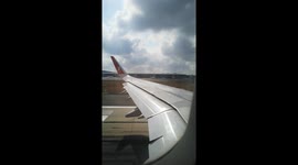 View from the window of an airplane's wing during takeoff during the day