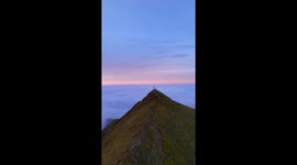 Drone footage on snowdonia, wales largest mountain overlooking a cloud inversion at 7am
