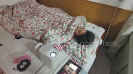 Girl watches TV series projected on ceiling in Beijing, China