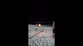 Friends play fiery beach ball game in Niterói, Brazil