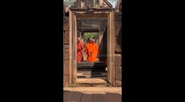 Young Buddhist monks make picturesque scene as they walk through ancient temple doorway