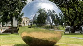 Timelapse of large mirrored ball in singapore reflecting the city skyline