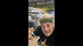 Alligator handler shows danger of turning your back when feeding an enclosure full of the hungry reptiles