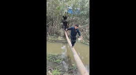 People cross flooded river on hanging pipe in Jiangsu, China