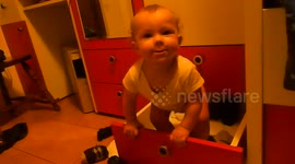 Funny baby messing with the socks drawer