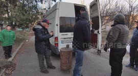 Video filmed in Bakhmut on November 30, 2022, showing volunteers distributing portable stoves and food supplies to local residents in a city that has been without water and electricity for several months. Some faces are visible in close-up.