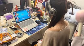 Friend hits gamer with massage sticks while she follows the beat