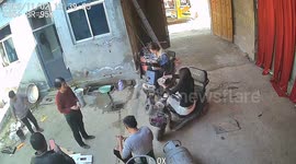 Young woman tips over while sitting on electric bike during cheerful gathering in Shandong, China.