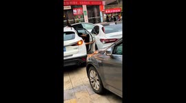Young boy carefully exits car to avoid hitting nearby vehicle in Nanchang, China