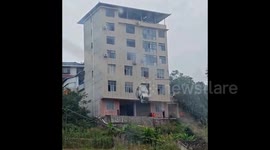 小货车撞破楼房墙体 半截车身悬空险坠楼