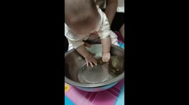 Child joyfully catches fish in bowl in Heilongjiang, China