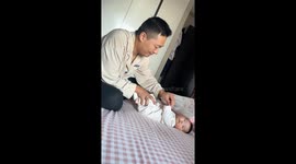 Father accidentally falls off bed while playing with baby in Liaoning, China