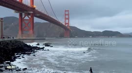 Surfers ride waves beneath San Francisco’s Golden Gate Bridge
