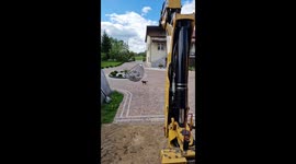 Girl swings in egg chair lifted by backhoe loader in Radzymin, Poland